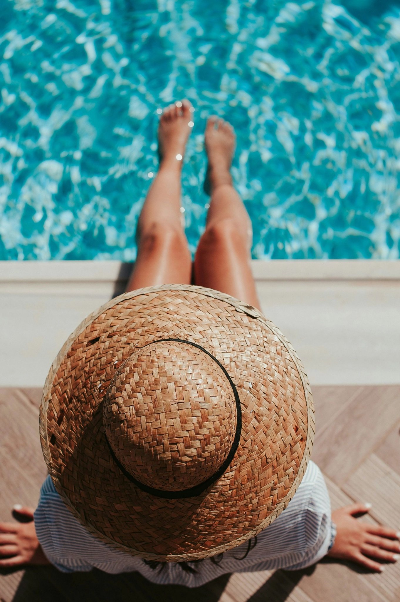 Person relaxing by a sparkling clean pool